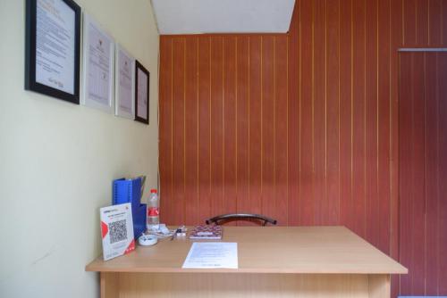 a desk with a sink and a wooden wall at Urbanview Hotel Telu Wolu Monjali by RedDoorz in Kejayan