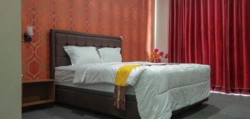 a bedroom with a bed with red walls and red curtains at Edhotel Kusuma Atambua Mitra RedDoorz in Tatakiren