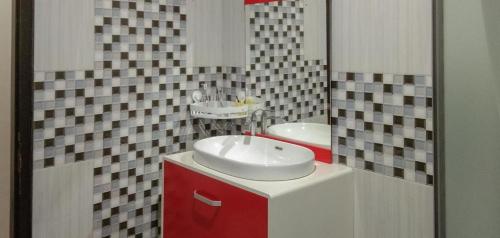 a bathroom with a white sink and a red cabinet at Edhotel Kusuma Atambua Mitra RedDoorz in Tatakiren