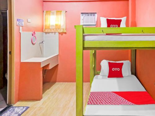 a small room with two bunk beds and a sink at OYO 868 Solanos Transient House in Manila