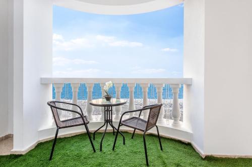 a table and two chairs in a room with a window at Live and experience a stunning Sea View Studio in Ras al Khaimah