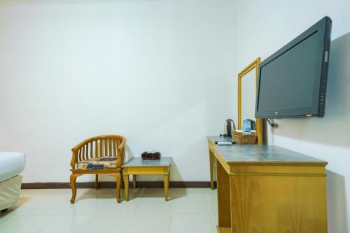 a living room with a tv on a dresser at Urbanview by Millenium Hotel in Pangkalpinang