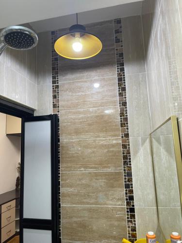 a bathroom with a shower with a tile wall at Villa Prisha in Bayan Lepas