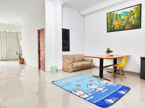 a living room with a table and a chair at Homey Guesthouse Kertajaya (Syariah) in Surabaya