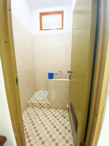 a bathroom with a toilet and a sink at Homey Guesthouse Kertajaya (Syariah) in Surabaya