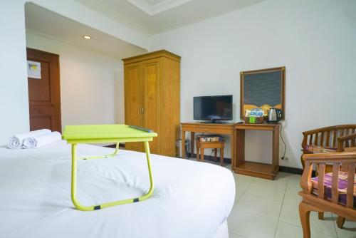 a room with a bed with a green table on it at Urbanview by Millenium Hotel in Pangkalpinang