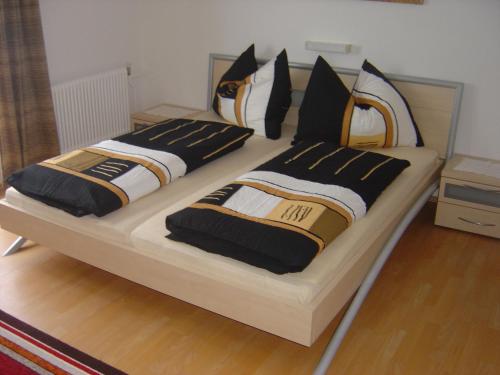 1 Schlafzimmer mit 2 Betten mit schwarzen und weißen Kissen in der Unterkunft Haus Alpenblick in Wenns