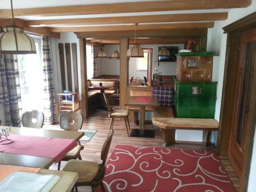ein Wohnzimmer mit Tischen und Stühlen sowie eine Küche in der Unterkunft Haus Alpenblick in Wenns