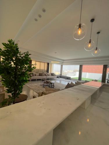 duży biały stół w salonie z rośliną w obiekcie القمة العالية w mieście Abha