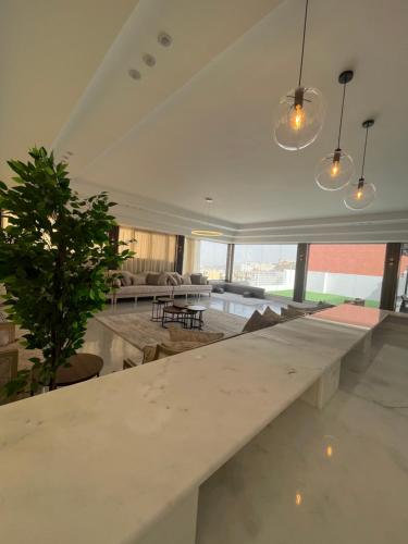 a large white table in a living room with a plant at القمة العالية in Abha