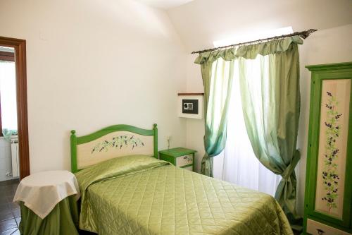 a bedroom with a green bed and a window at La Villetta Food & Drink Rooms for Rent - No Reception - in LʼAquila