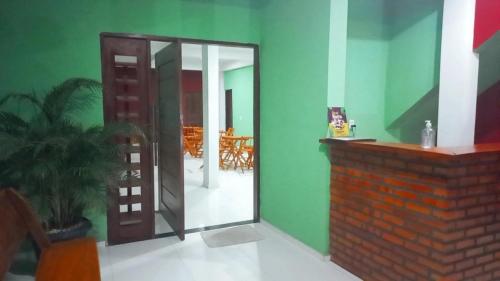 a room with a mirror and a green wall at Pousada Lençóis do Delta in Tutóia
