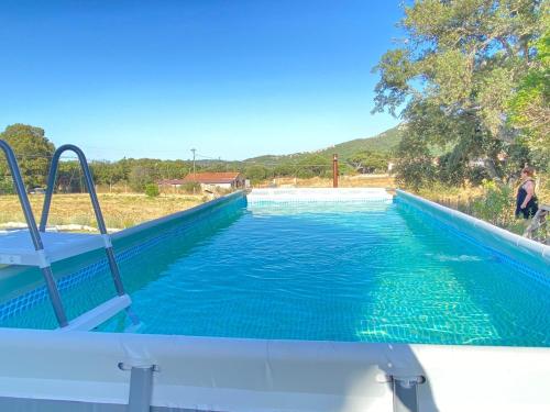 a pool of blue water with a slide in it at Casa di Campagna in Gallura in Luogosanto