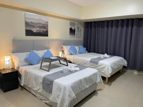 a hotel room with two beds with blue pillows at Serin Tagaytay Staycation in Tagaytay