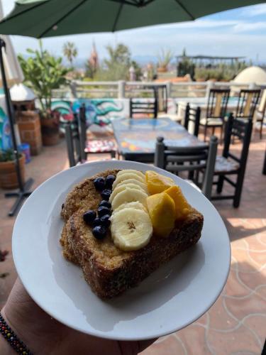 a plate with a piece of bread with bananas and blueberries at Hotel del Sol in San Miguel de Allende
