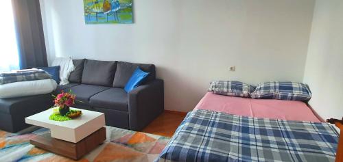 sala de estar con sofá y cama en Krymo g. Lovely 2 room flat in Šiauliai, near Akropolis en Šiauliai