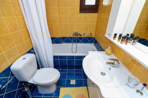 a bathroom with a toilet and a sink and a tub at Zmas Apartment in Chorto