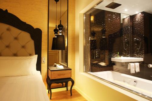 um quarto de hotel com uma cama e uma banheira em Silk Motel em Pedroso