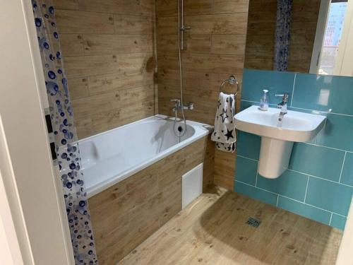 a bathroom with a tub and a sink and a bath tub at Apartament nemaipomenit, nou, in Complex Rezid Ared in Arad