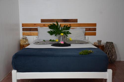 a bedroom with a bed with a plant on it at Le Pôle in Grand Baie