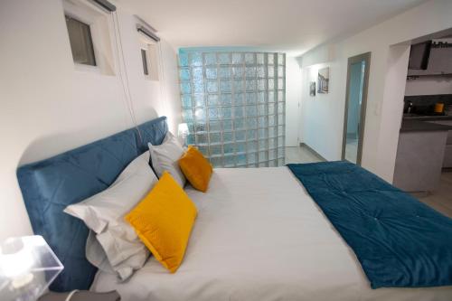 a bedroom with a large bed with yellow and blue pillows at Rochecorbon Le Gite des Clouet "Labellisé Loire A Vélo" in Rochecorbon