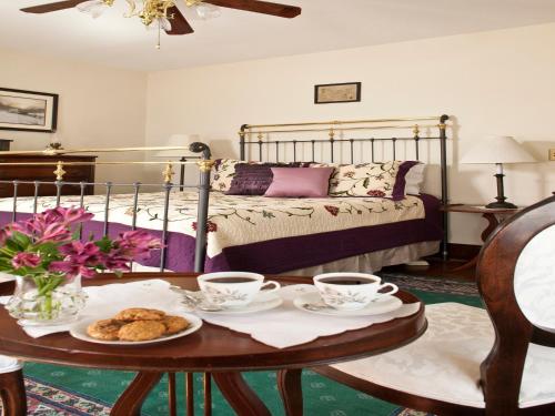 a room with a bed and a table with cups and cookies at Brickhouse Inn B&B in Gettysburg