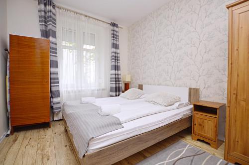 Habitación pequeña con cama y ventana en Atlante Apartment Dolny Sopot, en Sopot