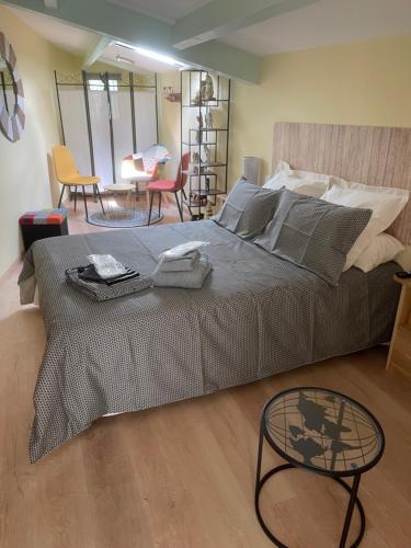 um quarto com uma cama grande com uma mesa e cadeiras em Gîte les Noisetiers Maison familiale avec piscine em Joze