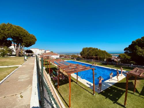 a swimming pool with people playing in the water at Mirador del Atlántico in El Rompido