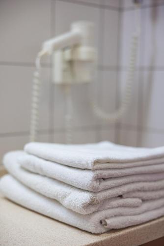 a pile of towels sitting on a counter in a bathroom at Info Hotel in Palanga