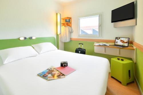 A bed or beds in a room at ibis budget Clermont Ferrand Sud