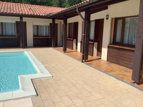 a house with a swimming pool next to a building at la dolce farniente in Biaudos