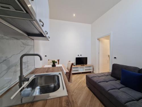 a kitchen and living room with a couch and a sink at Arial Trinity Suites in Vlorë