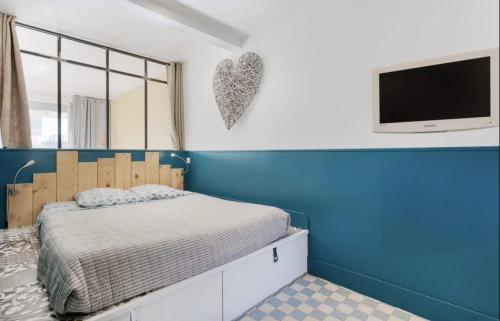 une chambre avec un lit et une télévision sur un mur dans l'établissement Croisette Beach Cannes Banane 4 sleeps Apart, à Cannes