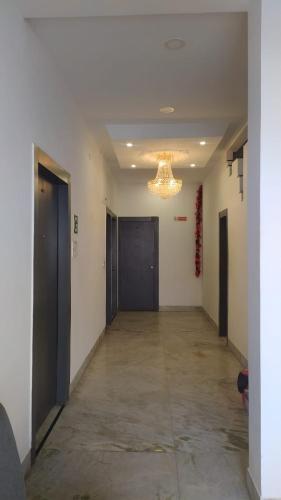 an empty hallway with doors and a chandelier at Hotel Nisha Nest, Bhopal in Bhopal