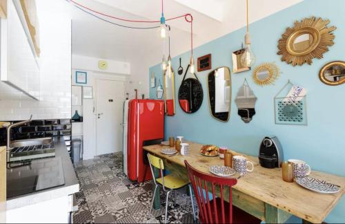 Il comprend une cuisine équipée d'une table en bois et d'un réfrigérateur rouge. dans l'établissement Croisette Beach Cannes Banane 4 sleeps Apart, à Cannes