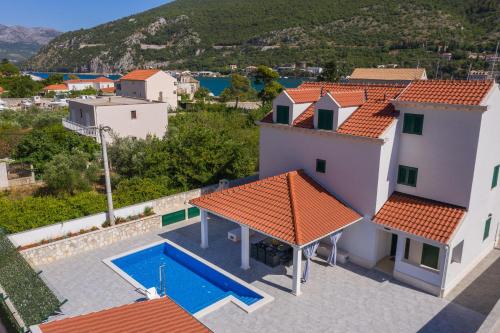 ein Bild eines Hauses mit Pool in der Unterkunft Villa Larum in Mokošica