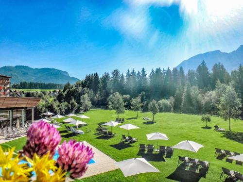 a green field with umbrellas and tables and chairs at Aldiana Club Salzkammergut und GrimmingTherme in Bad Mitterndorf