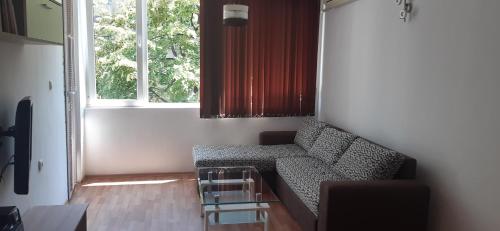 a living room with a couch and a window at Nana's apartment in Varna City