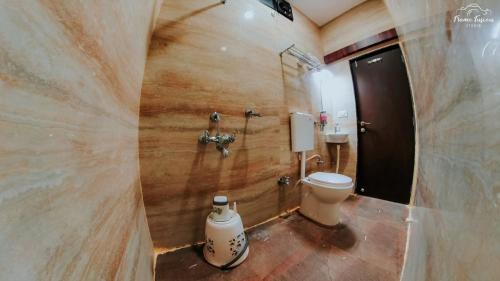 a bathroom with a toilet and a shower stall at Bajaj's Karwan Inn in Jagdalpur