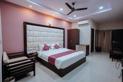 a bedroom with a large bed and a chair at Bajaj's Karwan Inn in Jagdalpur