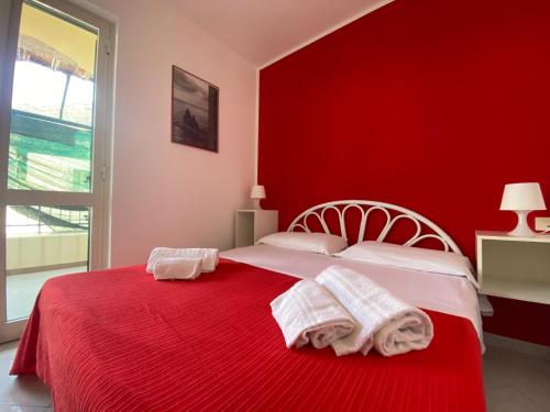 a red bedroom with a bed with towels on it at CannetoMare in Canneto
