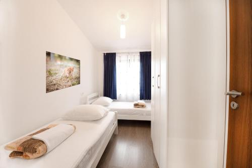 a white room with two beds and a window at Apartments MiraSol in Umag