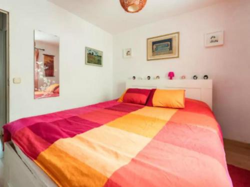 a bedroom with a large bed with a colorful blanket at La Adicidad de Castellón in Móstoles