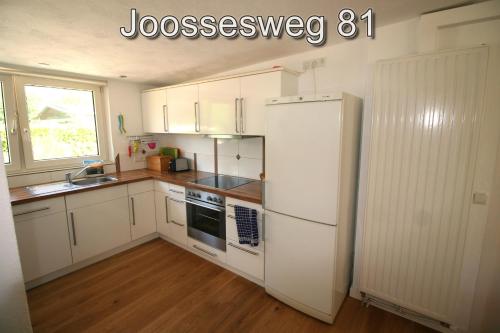 ヴェストカペレにあるJoossesweg 81の白いキャビネットと白い冷蔵庫のあるキッチン