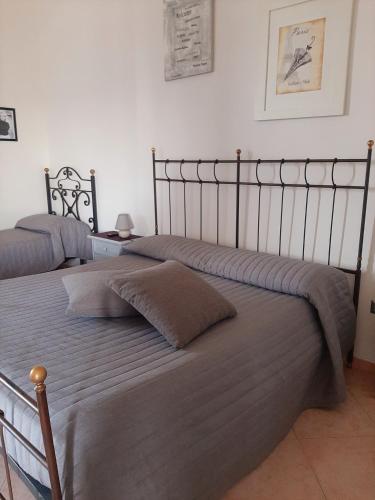 a bedroom with two beds with gray blankets at POMPEI VESEVUS APARTAMENT in Boscotrecase