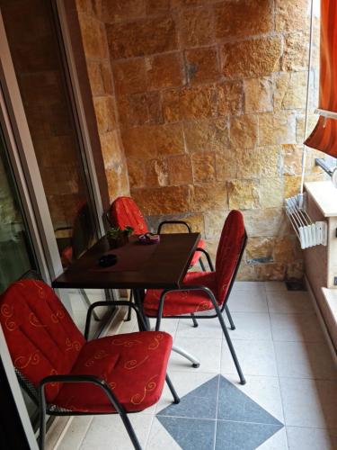 a table and chairs in a room with a brick wall at Apartman Centar Lux in Budva