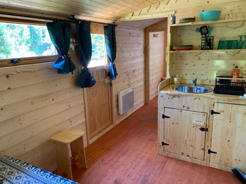 a kitchen in a log cabin with a sink at LA MAGNANERIE in Grillon