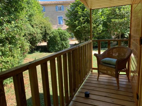 a porch with a wicker chair on a deck at LA MAGNANERIE in Grillon