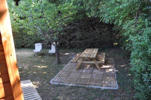 a picnic table and two chairs in a yard at LA MAGNANERIE in Grillon